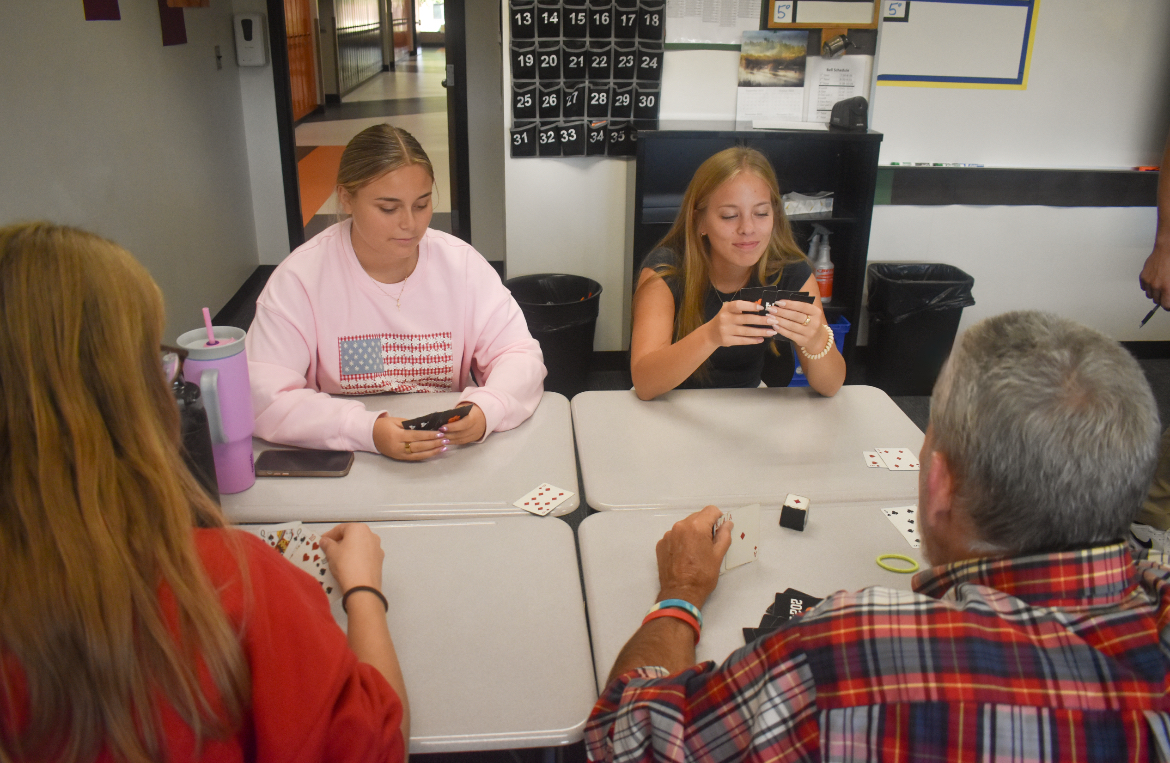 Senior Delania Maschke (upper left) and senior Kendall Eisinger (upper right) play euchre with junior Samantha Burns and Mr. Kevin McMahon at a Euchre Club meeting on Thursday, Sept. 11.