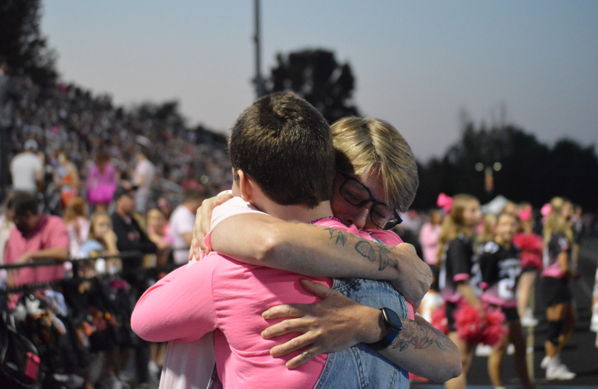 Senior Olive Mejia hugs her mom, Julie Mejia, after shaving her head in support of Pink Week's mission to honor those battling breast cancer. 