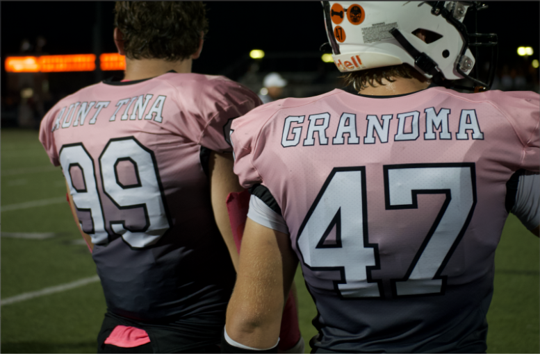 Senior defensive lineman Mason Grove (left) and junior defensive end Sullivan Haas (right) wear pink jerseys commemorating love ones who have battled cancer.