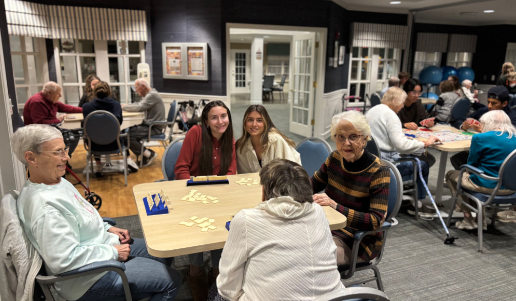 Senior Zoe Joseph and junior Stella Perri pose with elderly residents at Independence Village during a volunteering outing on Nov. 12 with the Community Impact Club.