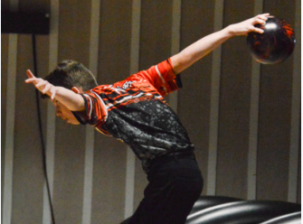Sophomore Jack Risner bowls one-handed, his preferred method in a heated debate among bowlers.