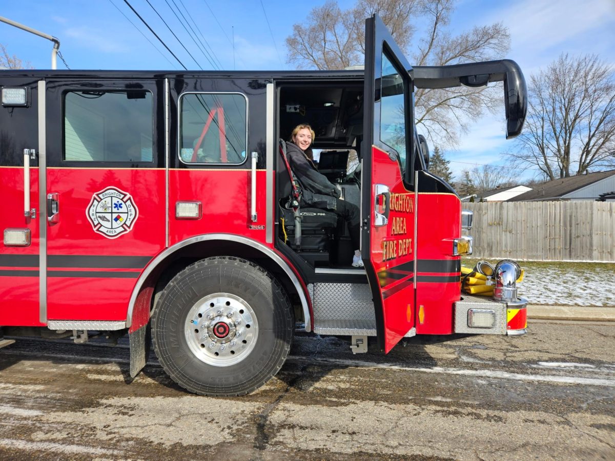 Senior Valerie Avellino poses in a fire truck during her clinical rotation at the Brighton Area Fire Department. She had the opportunity to work with them due to her involvement in Brighton High School's Health Occupations program.