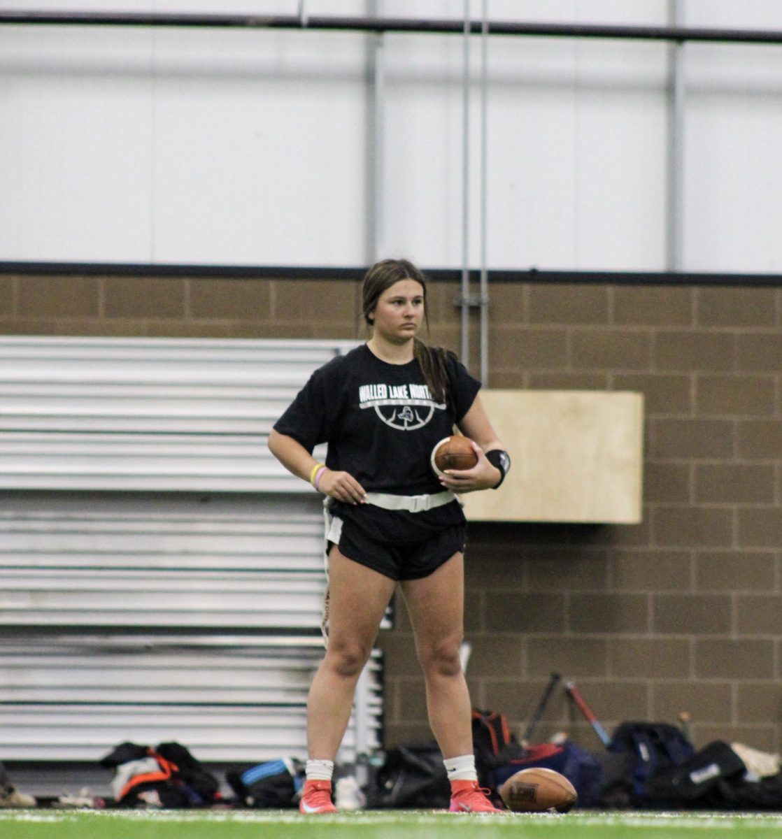 Senior Emma Adamczyk, quarterback for Brighton High School's women's flag football team, stands at the ready on the field. Adamczyk is one of many female athletes who have managed to attain success and collegiate opportunities in traditionally male-dominated sports thanks in part to Title IX.